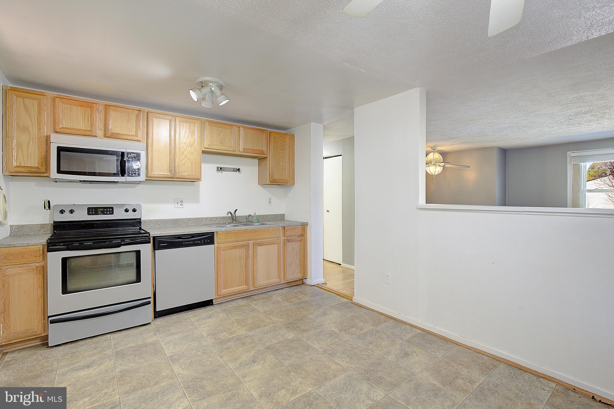 3611 Blackwater Road Clinton, MD 20735 - Photo 8 of 31 a kitchen with granite countertop a stove top oven microwave and cabinets