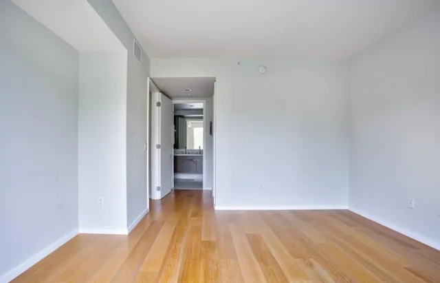 a view of a room with wooden floor and a bathroom