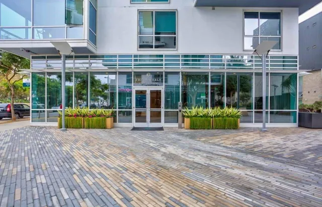 a view of a house with a large window and a yard with furniture