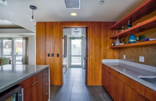 a kitchen with stainless steel appliances granite countertop wooden floors a sink and a refrigerator