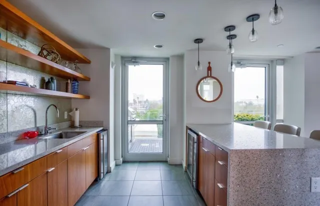 a kitchen with granite countertop a sink a stove top oven and cabinets