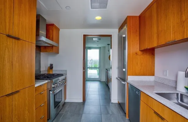 a kitchen with stainless steel appliances granite countertop a sink stove and cabinets