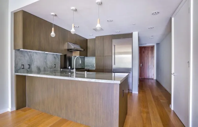 a kitchen with stainless steel appliances granite countertop a sink a stove and a refrigerator