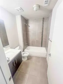 a bathroom with a sink a toilet a tub and shower