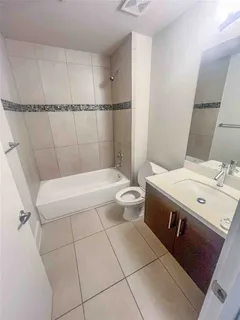 a bathroom with a sink a toilet a mirror and shower