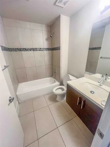 a bathroom with a sink a toilet a mirror and shower