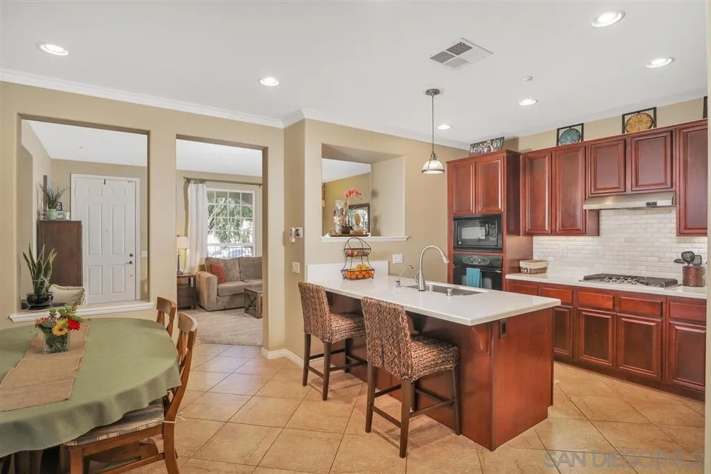 16691 Deer Ridge Road San Diego, CA 92127 - Photo 3 of 20 a large kitchen with kitchen island a sink table and chairs