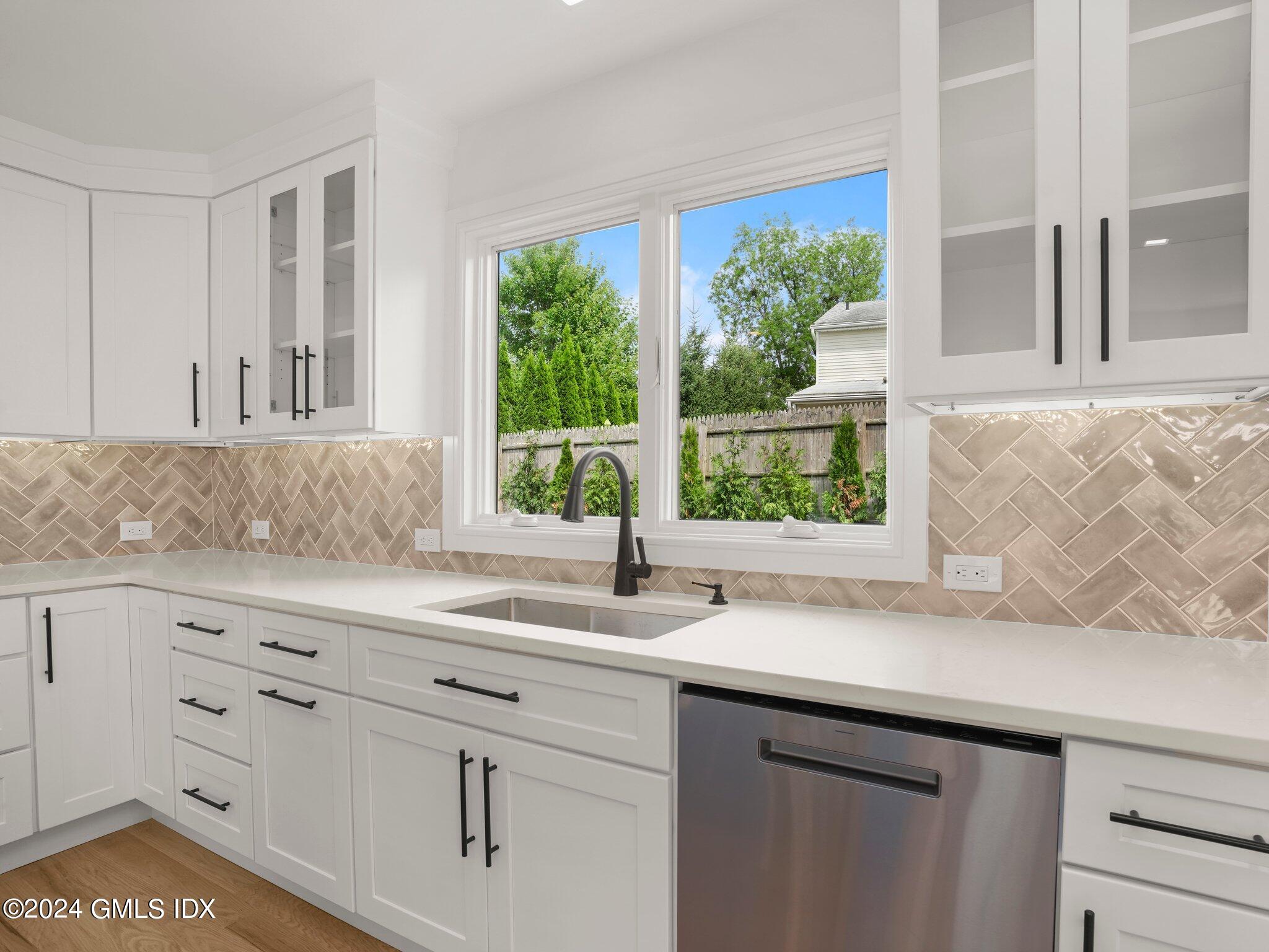14 Rockland Place Greenwich, CT 06831 - Photo 18 of 54 a kitchen with stainless steel appliances white cabinets and a large window