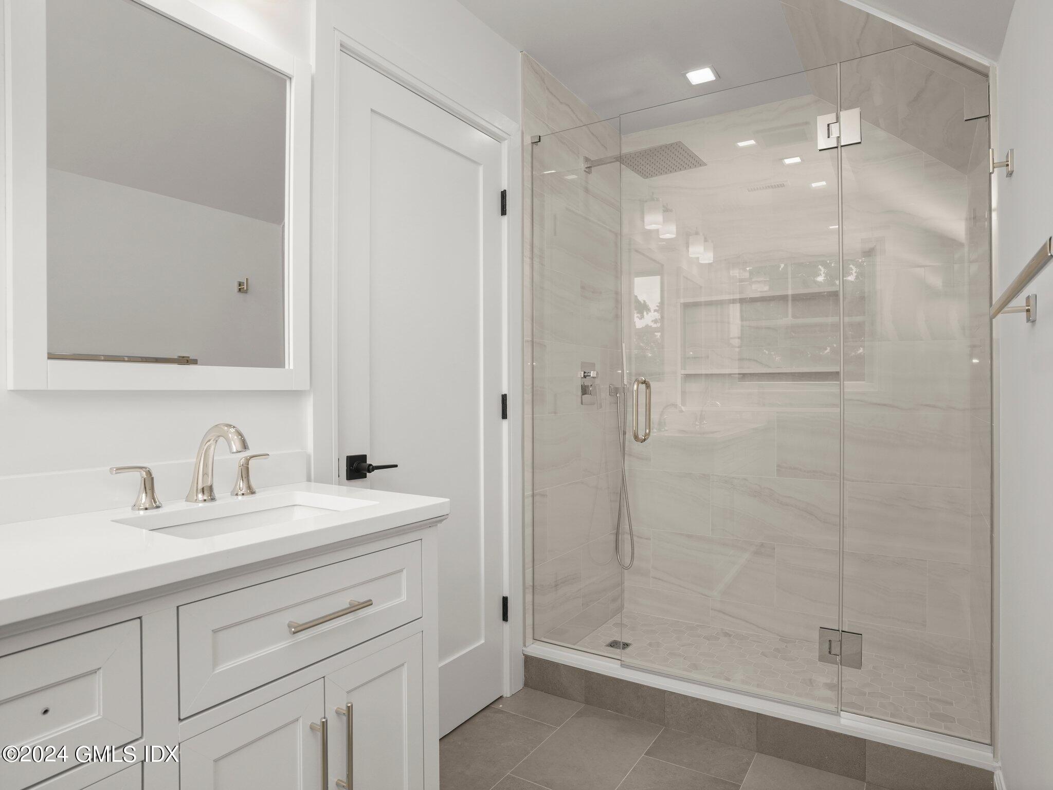 14 Rockland Place Greenwich, CT 06831 - Photo 40 of 54 a bathroom with a shower sink vanity and mirror