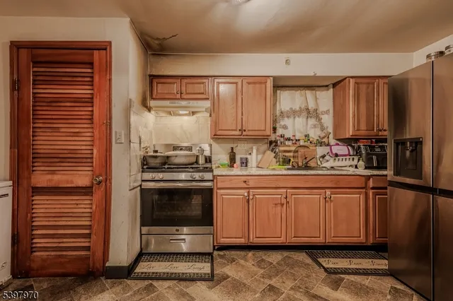 a kitchen with stainless steel appliances granite countertop a stove a sink and a refrigerator