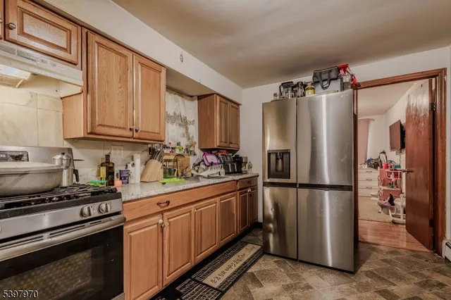 a kitchen with stainless steel appliances granite countertop a refrigerator stove and sink