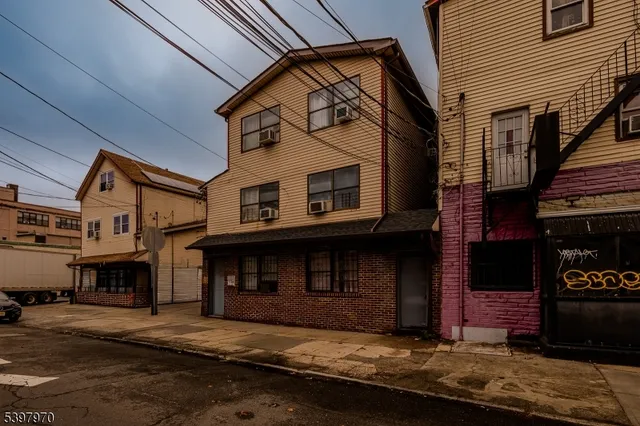a view of a white building with a small yard and large windows