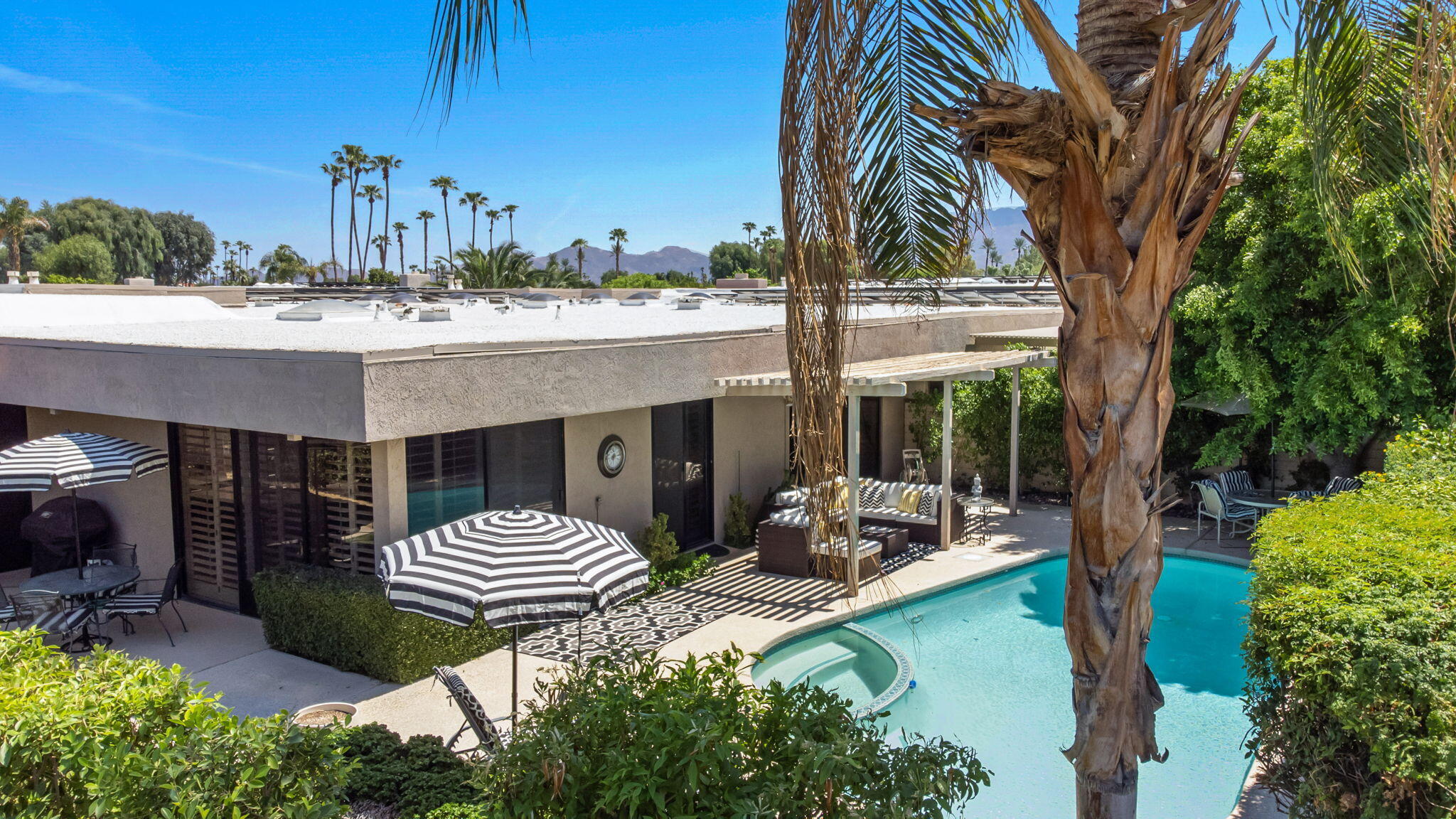 Undisclosed Address Rancho Mirage, CA 92270 - Photo 38 of 52 a view of a patio with table and chairs potted plants and a large tree
