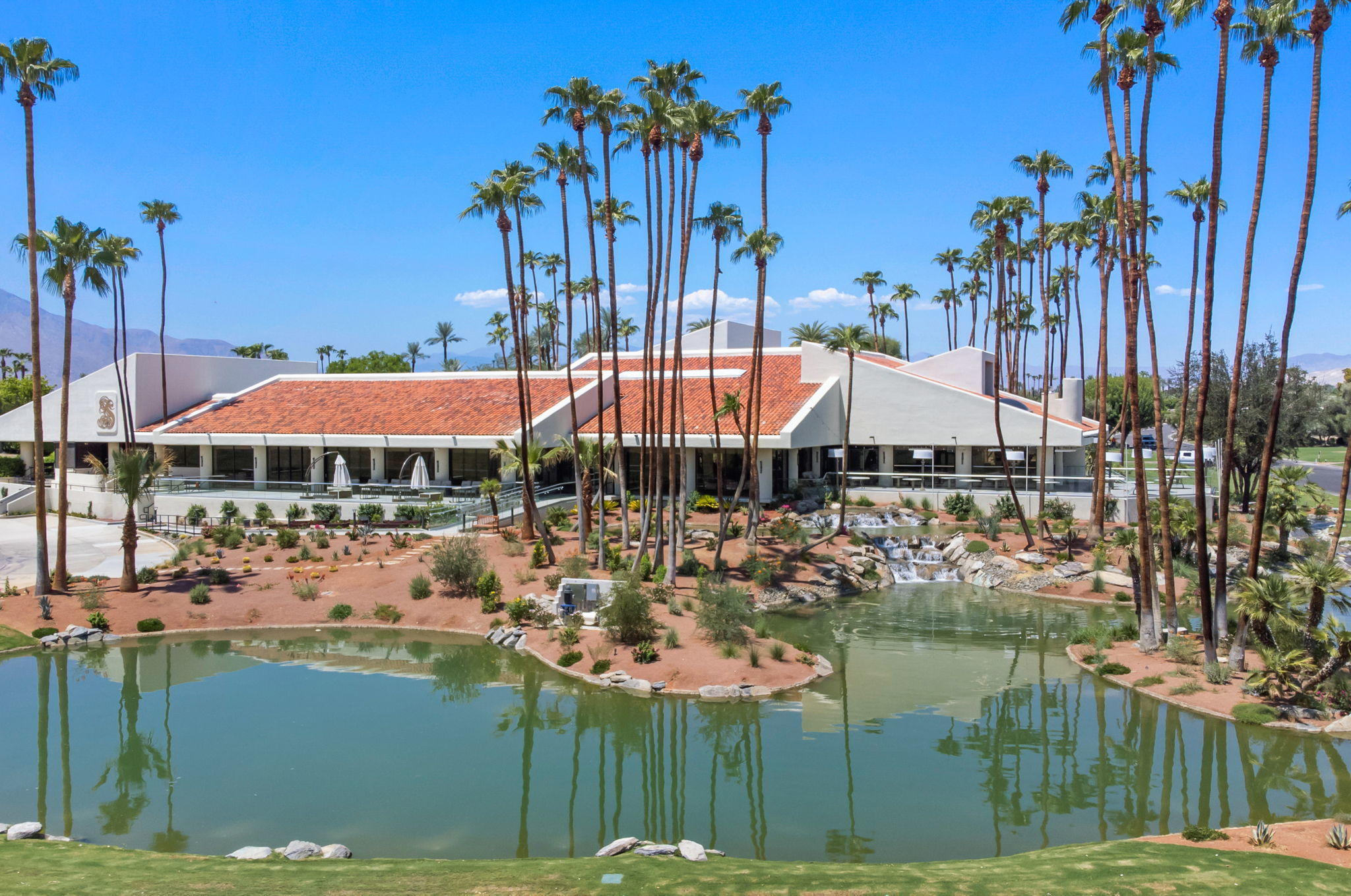 Undisclosed Address Rancho Mirage, CA 92270 - Photo 47 of 52 a view of a lake with a table and chairs under an umbrella