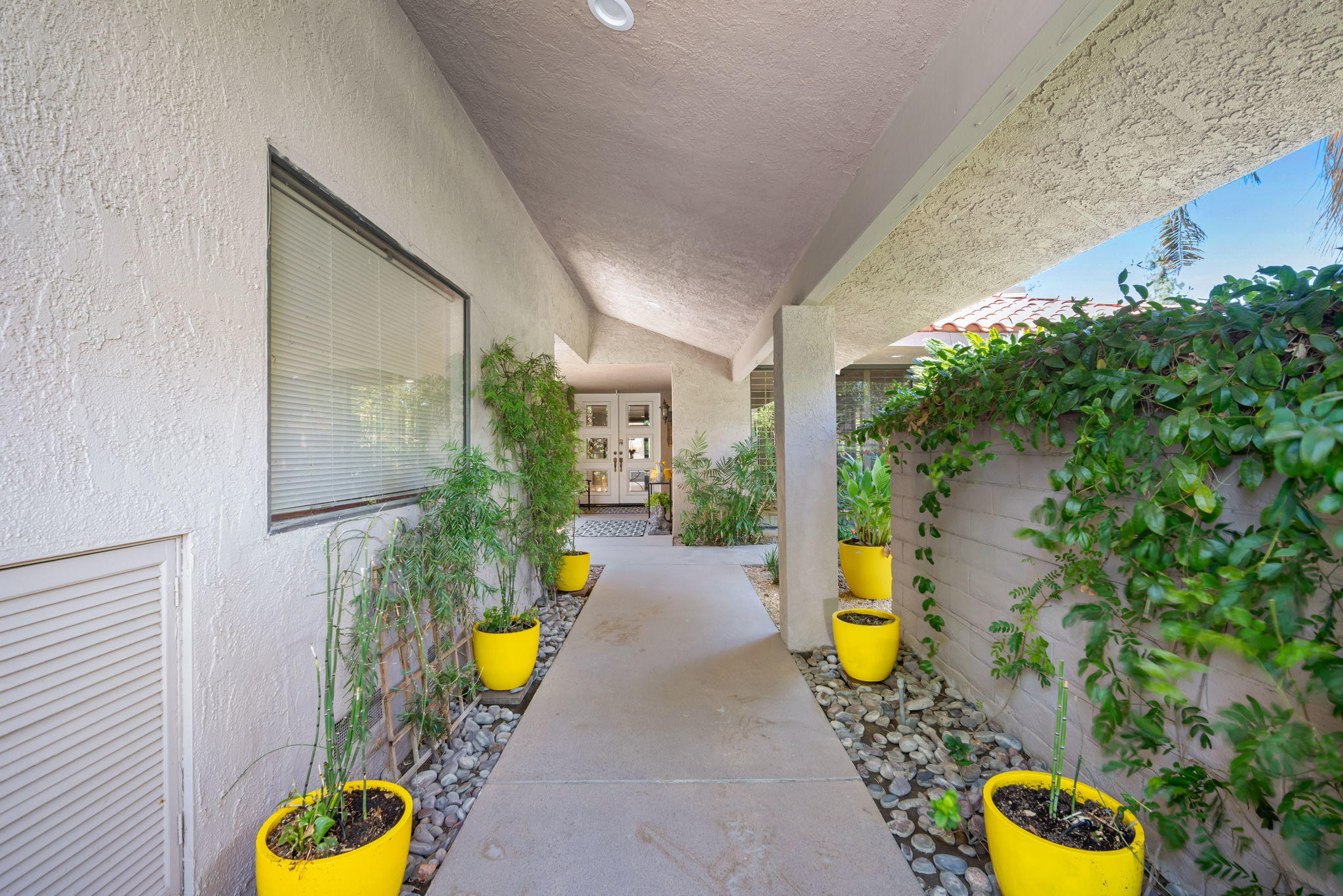 Undisclosed Address Rancho Mirage, CA 92270 - Photo 6 of 52 a view of a swimming pool with some potted plants in front of house