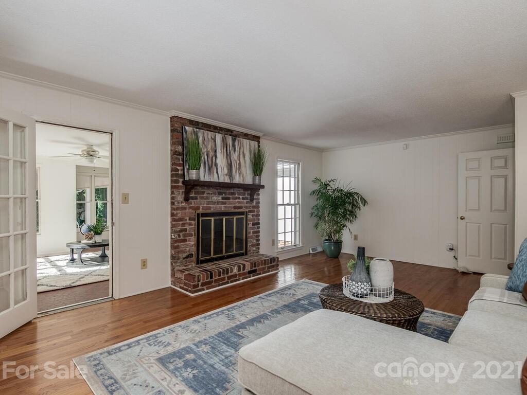 4920 Pine Ridge Road Charlotte, NC 28226 - Photo 12 of 28 a living room with furniture a fireplace and wooden floor