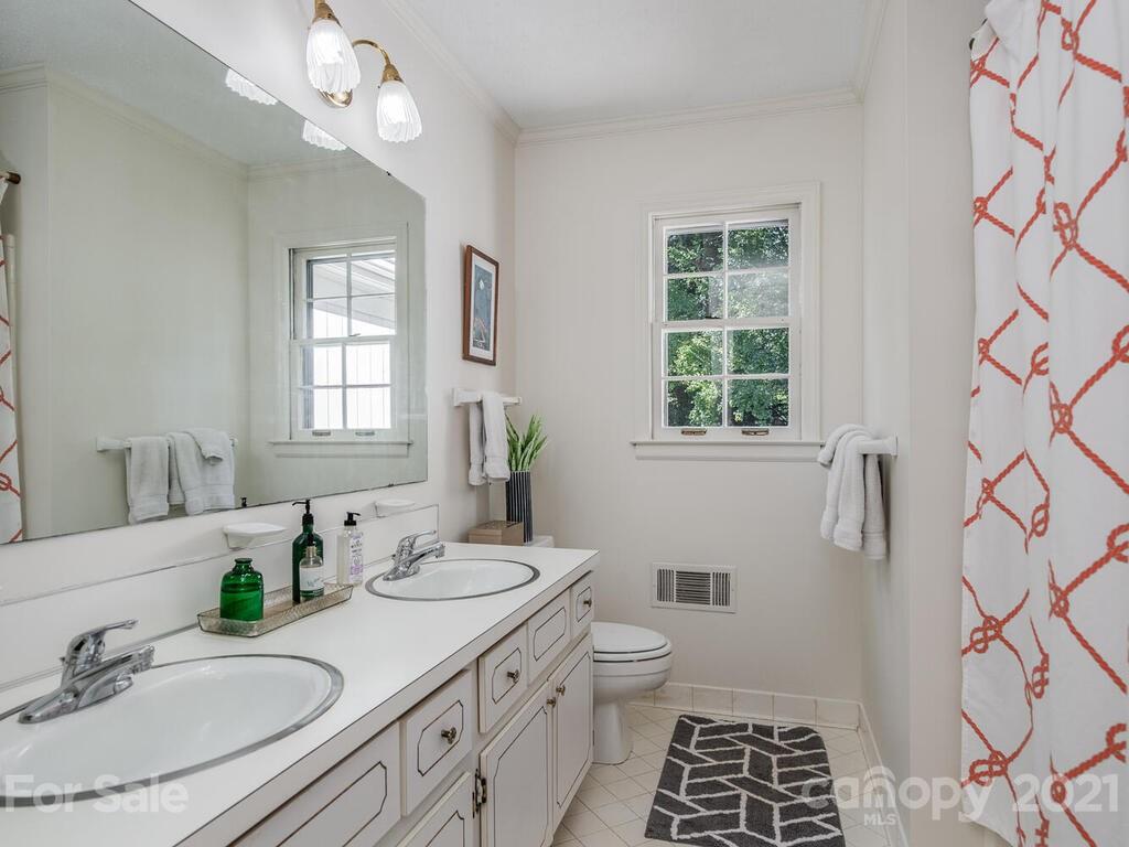 4920 Pine Ridge Road Charlotte, NC 28226 - Photo 19 of 28 a bathroom with a granite countertop sink a toilet a mirror and a window