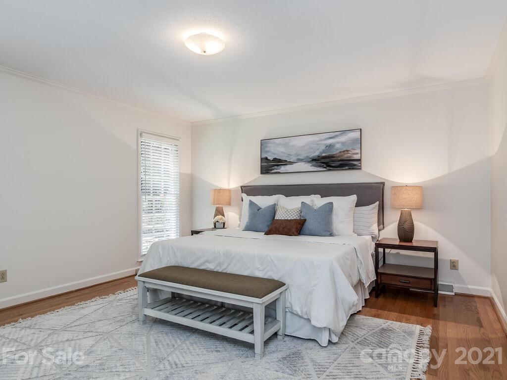 4920 Pine Ridge Road Charlotte, NC 28226 - Photo 21 of 28 a bedroom with a bed and a lamp