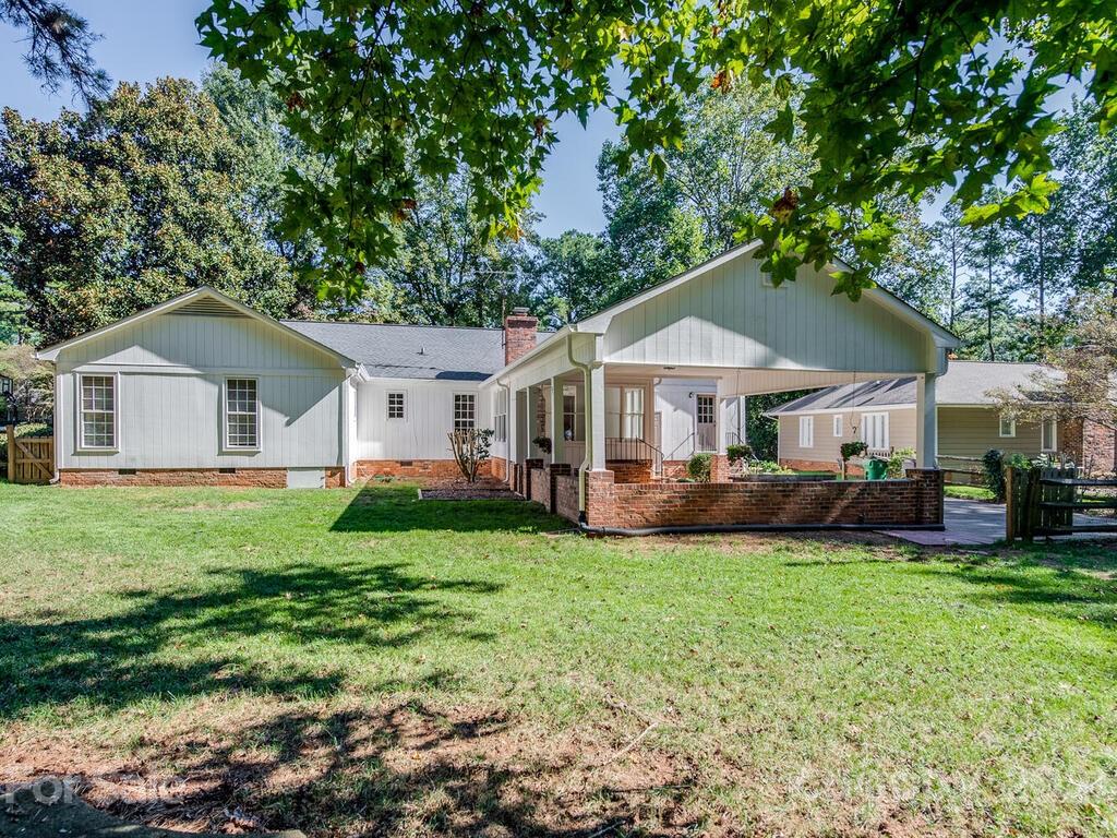 4920 Pine Ridge Road Charlotte, NC 28226 - Photo 27 of 28 a front view of a house with a garden and trees