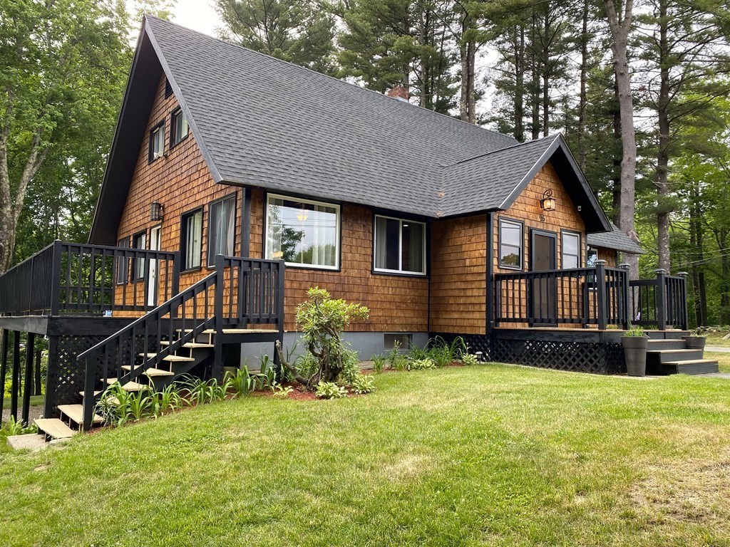 a backyard of a house with wooden fence and a tree
