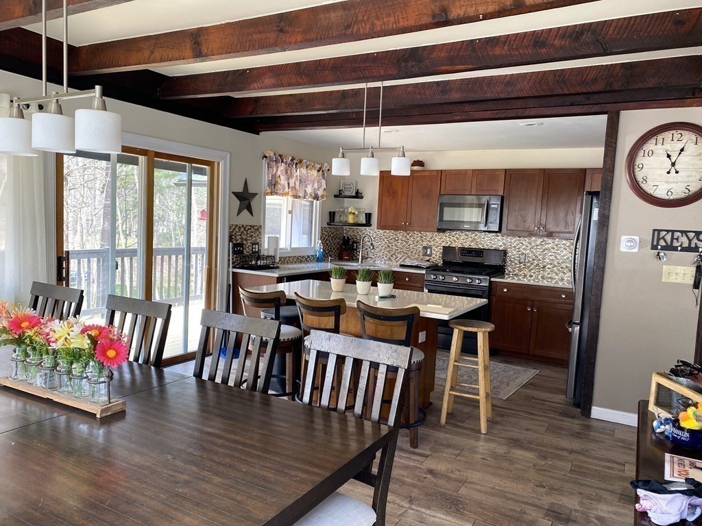 95 Franklin Street Douglas, MA 01516 - Photo 15 of 40 a dining room with wooden floor a chandelier a wooden table and chairs