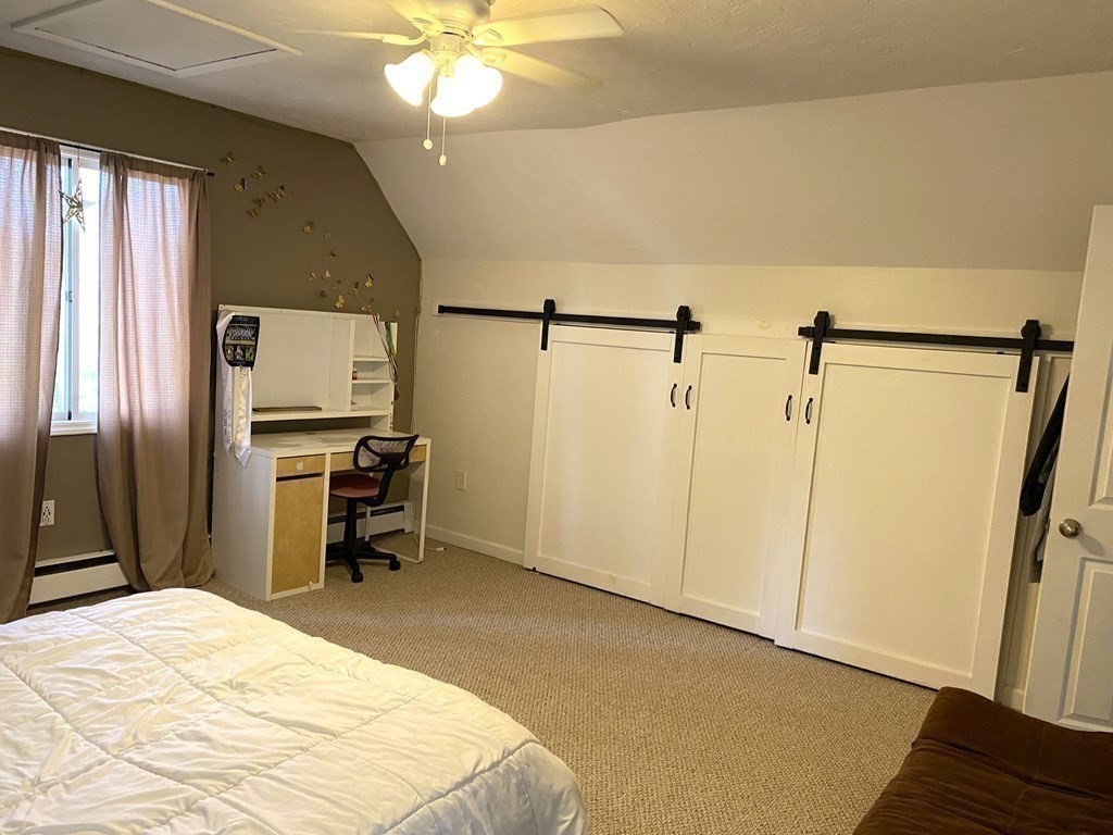 95 Franklin Street Douglas, MA 01516 - Photo 29 of 40 a bedroom with a bed and a chandelier