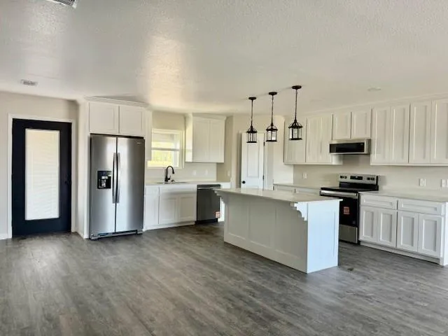 a kitchen with stainless steel appliances a refrigerator sink and cabinets