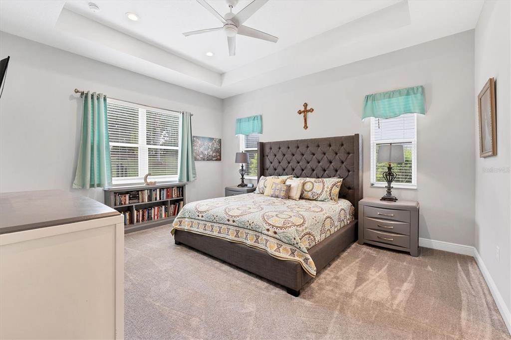 13306 Deep Blue Place Bradenton, FL 34211 - Photo 19 of 73 a bedroom with a large bed and a chandelier