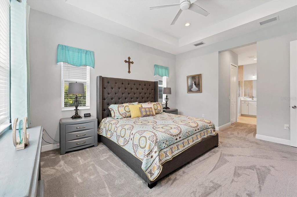 13306 Deep Blue Place Bradenton, FL 34211 - Photo 20 of 73 a bedroom with a large bed and a chandelier