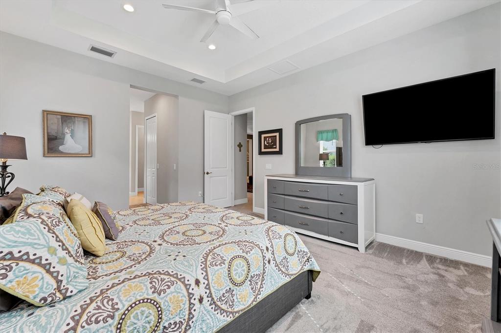 13306 Deep Blue Place Bradenton, FL 34211 - Photo 21 of 73 a bedroom with a bed and a flat screen tv in it