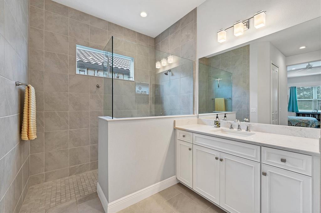 13306 Deep Blue Place Bradenton, FL 34211 - Photo 24 of 73 a bathroom with a double vanity sink a mirror and a shower