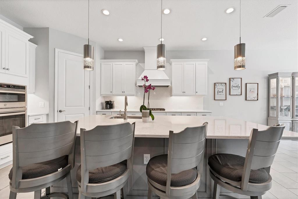 13306 Deep Blue Place Bradenton, FL 34211 - Photo 6 of 73 a dining room with stainless steel appliances kitchen island a table and chairs