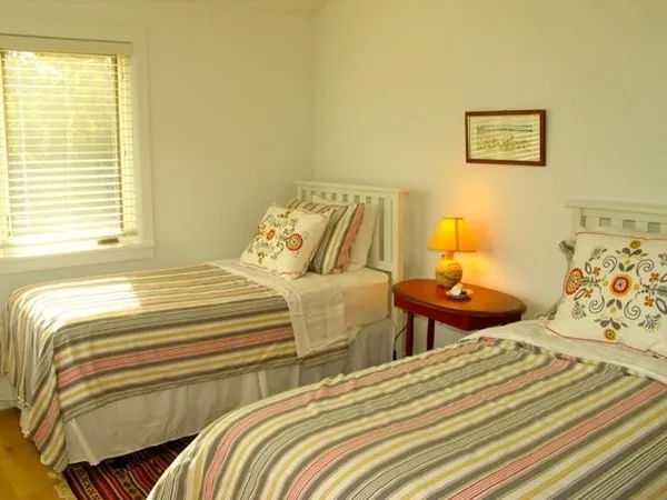 a bedroom with two beds and painting on the wall