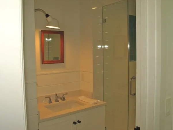 a bathroom with a sink shower and a mirror