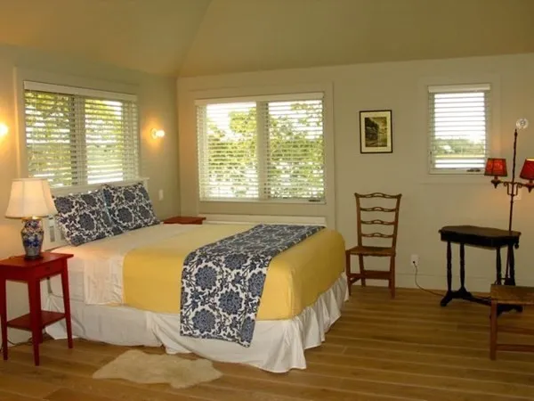 a bed sitting in a bedroom next to a window