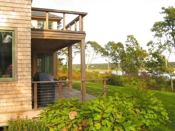 a view of a porch with a table and chairs next to a yard