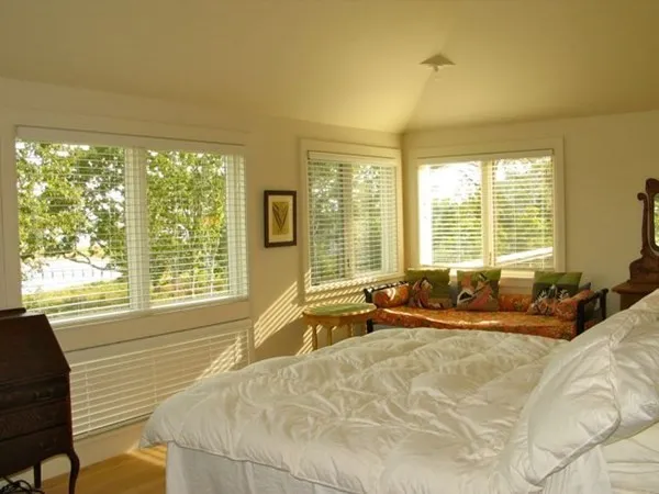 a spacious bedroom with a bed and large windows