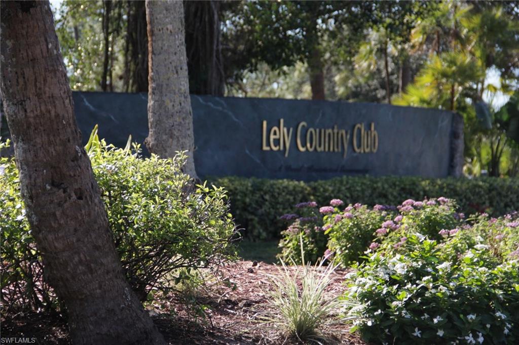 5841 Rattlesnake Hammock Road, Unit I206 Naples, FL 34113 - Photo 24 of 24 a sign that is in front of flowers