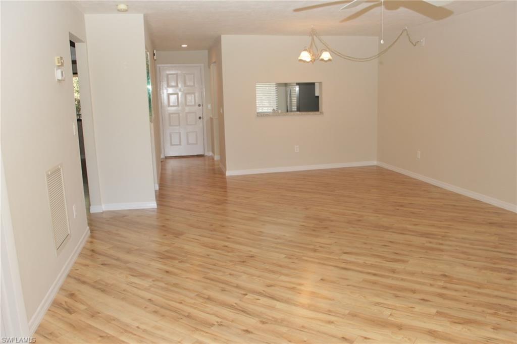 5841 Rattlesnake Hammock Road, Unit I206 Naples, FL 34113 - Photo 4 of 24 a view of a hallway with wooden floor