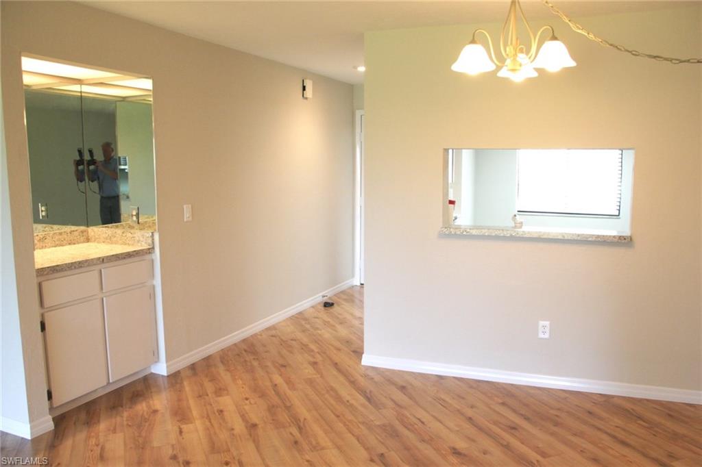 5841 Rattlesnake Hammock Road, Unit I206 Naples, FL 34113 - Photo 5 of 24 wooden floor in an empty room with a window