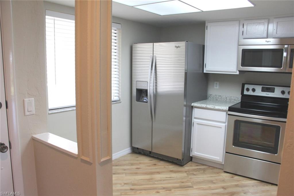 5841 Rattlesnake Hammock Road, Unit I206 Naples, FL 34113 - Photo 6 of 24 a kitchen with stainless steel appliances granite countertop a refrigerator and a stove top oven