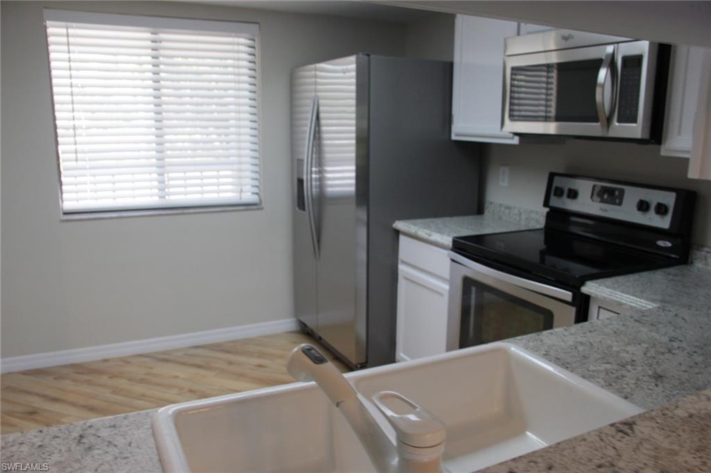 5841 Rattlesnake Hammock Road, Unit I206 Naples, FL 34113 - Photo 7 of 24 a kitchen with a stove and a microwave