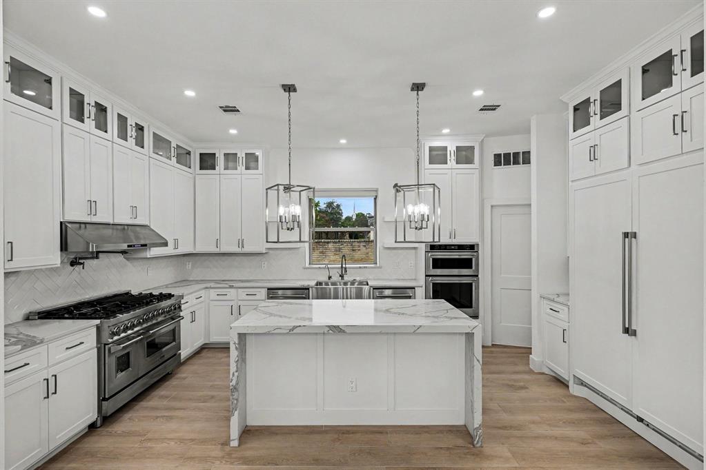17327 Davenport Road Dallas, TX 75248 - Photo 2 of 40 a kitchen with stainless steel appliances kitchen island granite countertop a refrigerator and a stove top oven
