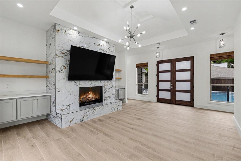 17327 Davenport Road Dallas, TX 75248 - Photo 23 of 40 a view of a livingroom with a fireplace wooden shelves and windows