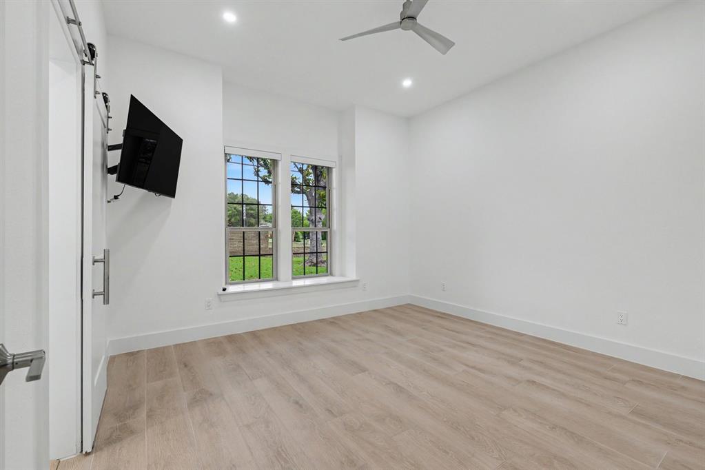 17327 Davenport Road Dallas, TX 75248 - Photo 29 of 40 an empty room with windows flat screen tv and ceiling fan