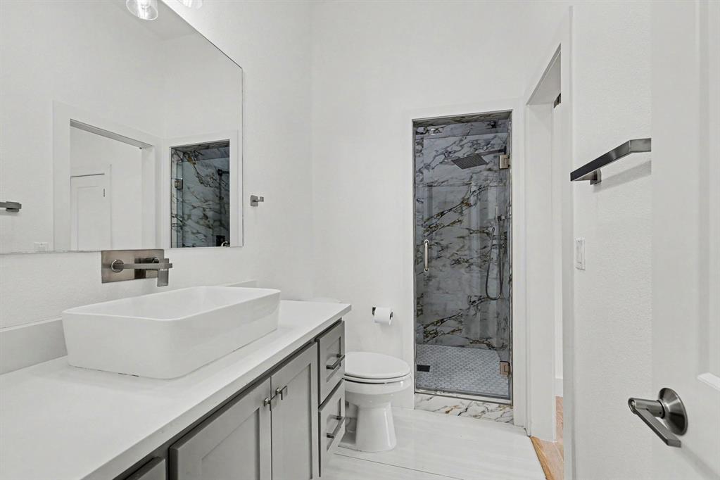 17327 Davenport Road Dallas, TX 75248 - Photo 33 of 40 a bathroom with a sink a toilet and shower