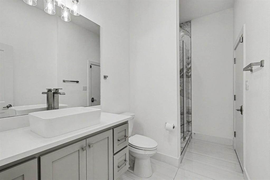 17327 Davenport Road Dallas, TX 75248 - Photo 35 of 40 a bathroom with a sink a toilet and shower