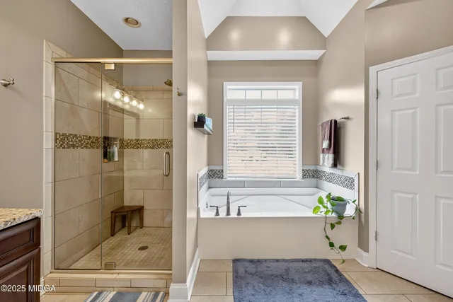 a spacious bathroom with a granite countertop tub sink and mirror