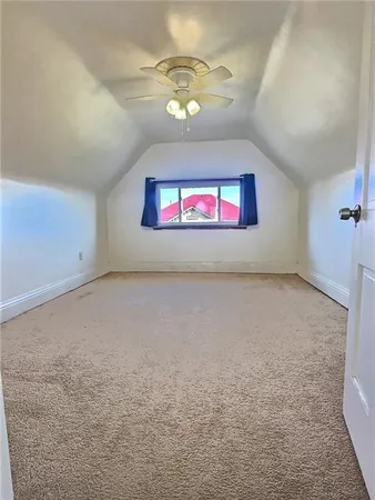 an empty room with windows and ceiling fan