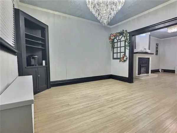 a view of empty room with a fireplace and wooden floor